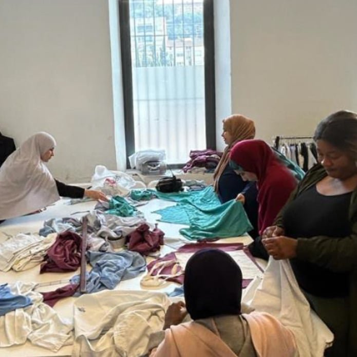 imatge de teixint esperances, on es veuen dues dones cosint